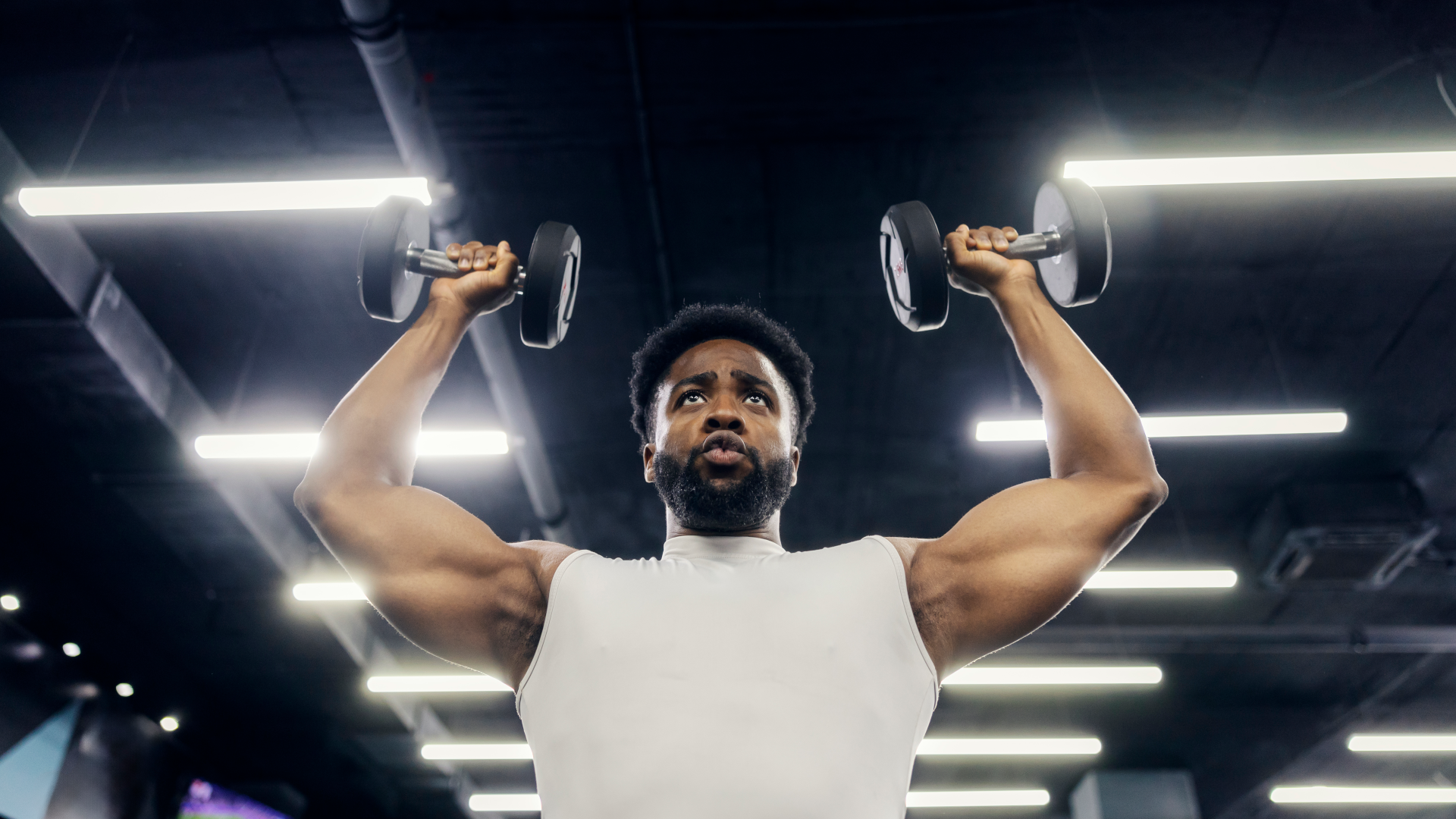 A man performing dumbbell shoulder press