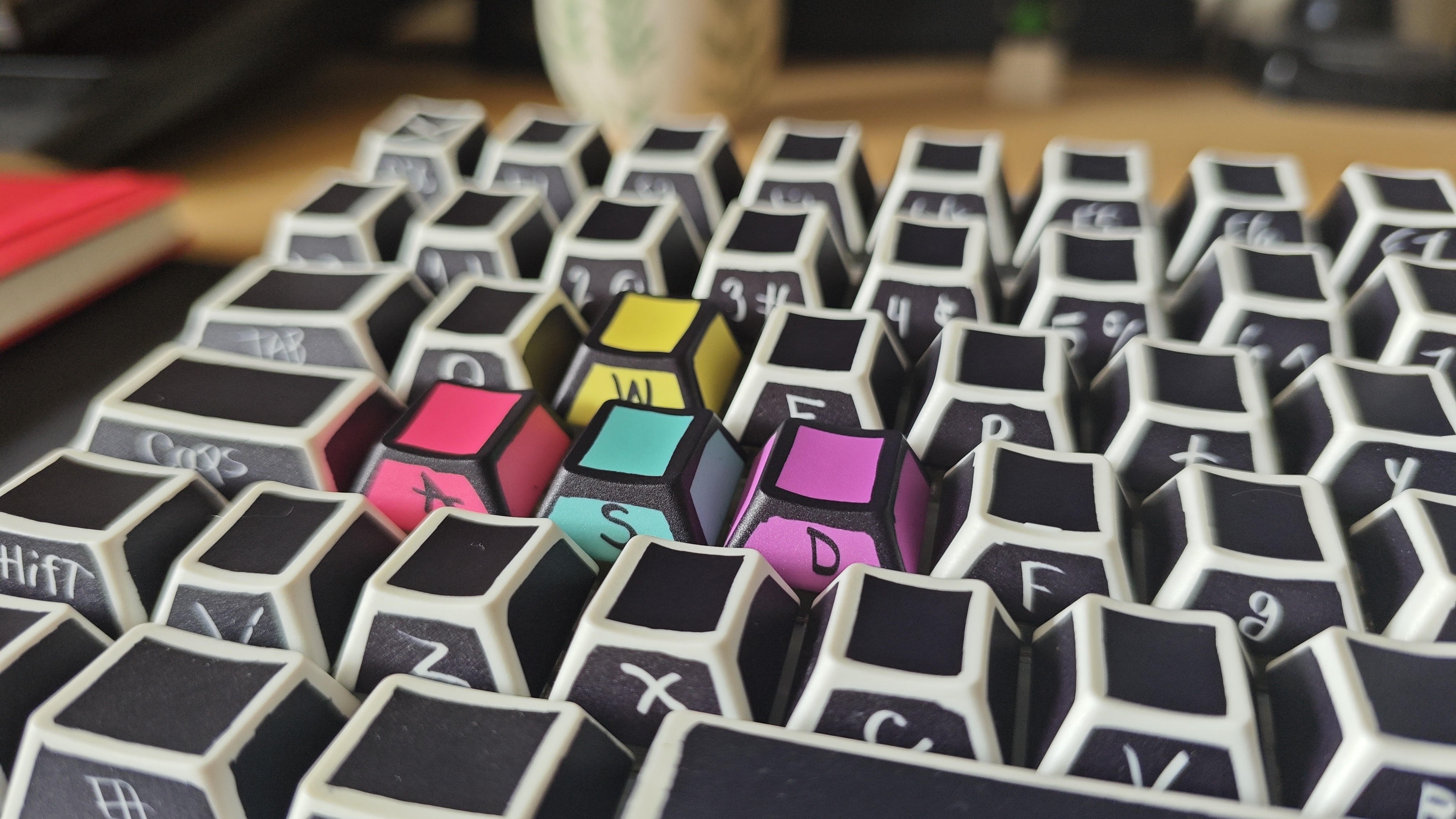 Glorious Sketch keycaps in black, white, red, blue, yellow, and purple, shot on a Poco F7 Pro phone