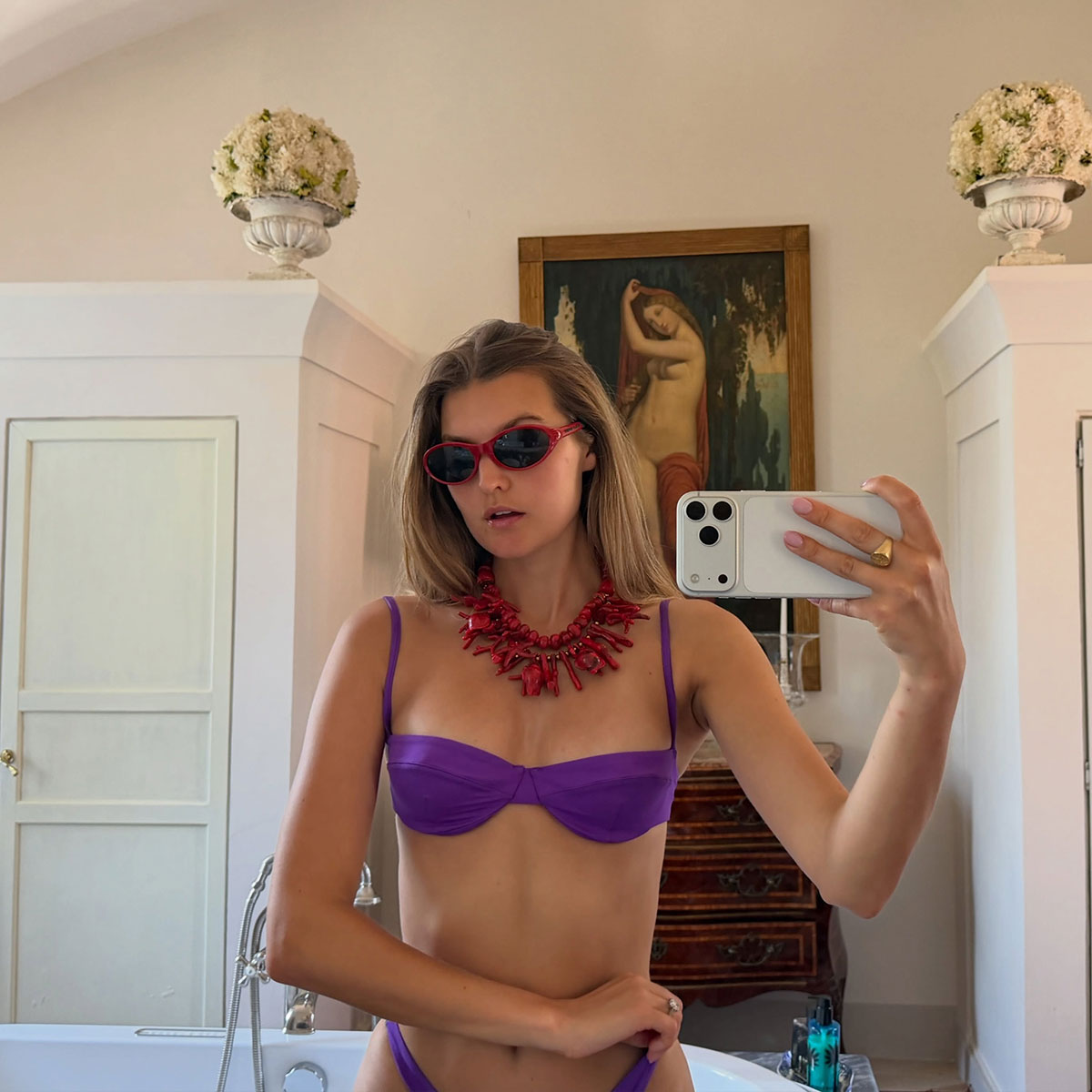@styledsara selfie in purple bikini with a red coral statement necklace