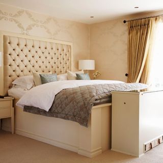 bedroom with headboard and wallpaper wall