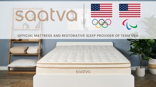 The Saatva Classic mattress on a bed frame in a bedrom. At the top of the image is the Saatva logo, the Team USA Olympic and Paralympic logo, and the words "Official mattress and restorative sleep provider of Team USA"