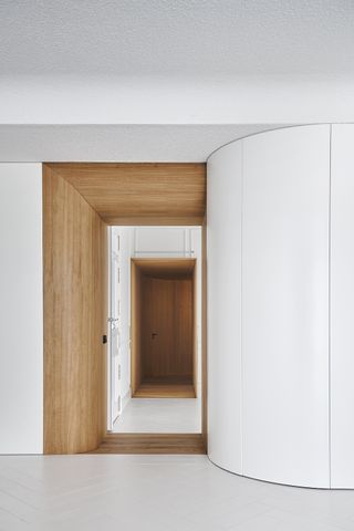 curved white wall and wooden doorway