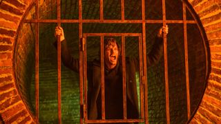 Jeremy Irvine as James Sunderland, screaming on the other side of a gate in Return to Silent Hill