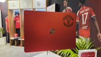 Microsoft Surface Laptop 13-inch 2nd Edition with Manchester United and Qualcomm Snapdragon branding on a red chassis, displayed with football imagery