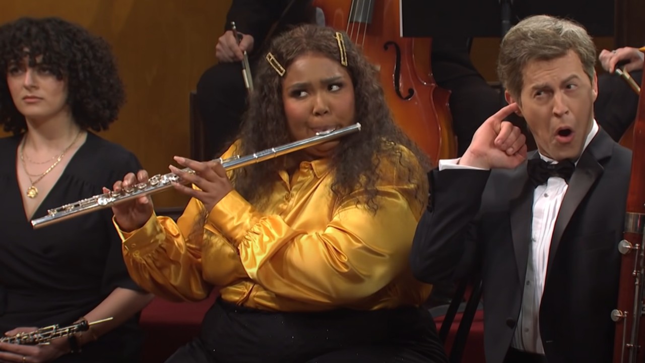 Lizzo playing the flute during a sketch on SNL