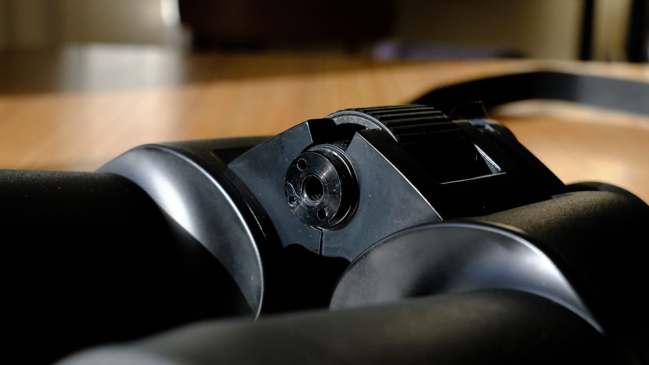 The binocular tripod adapter socket in between the barrels on the Nikon Action 16x50 binoculars.