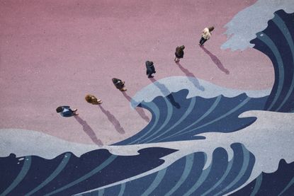 People standing in line next to big waves panted on asphalt – to illustrate Tina Fordham interview