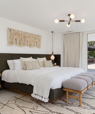 Mandy Moore's bedroom featuring white bedding, a greige rug, and a dark bedframe