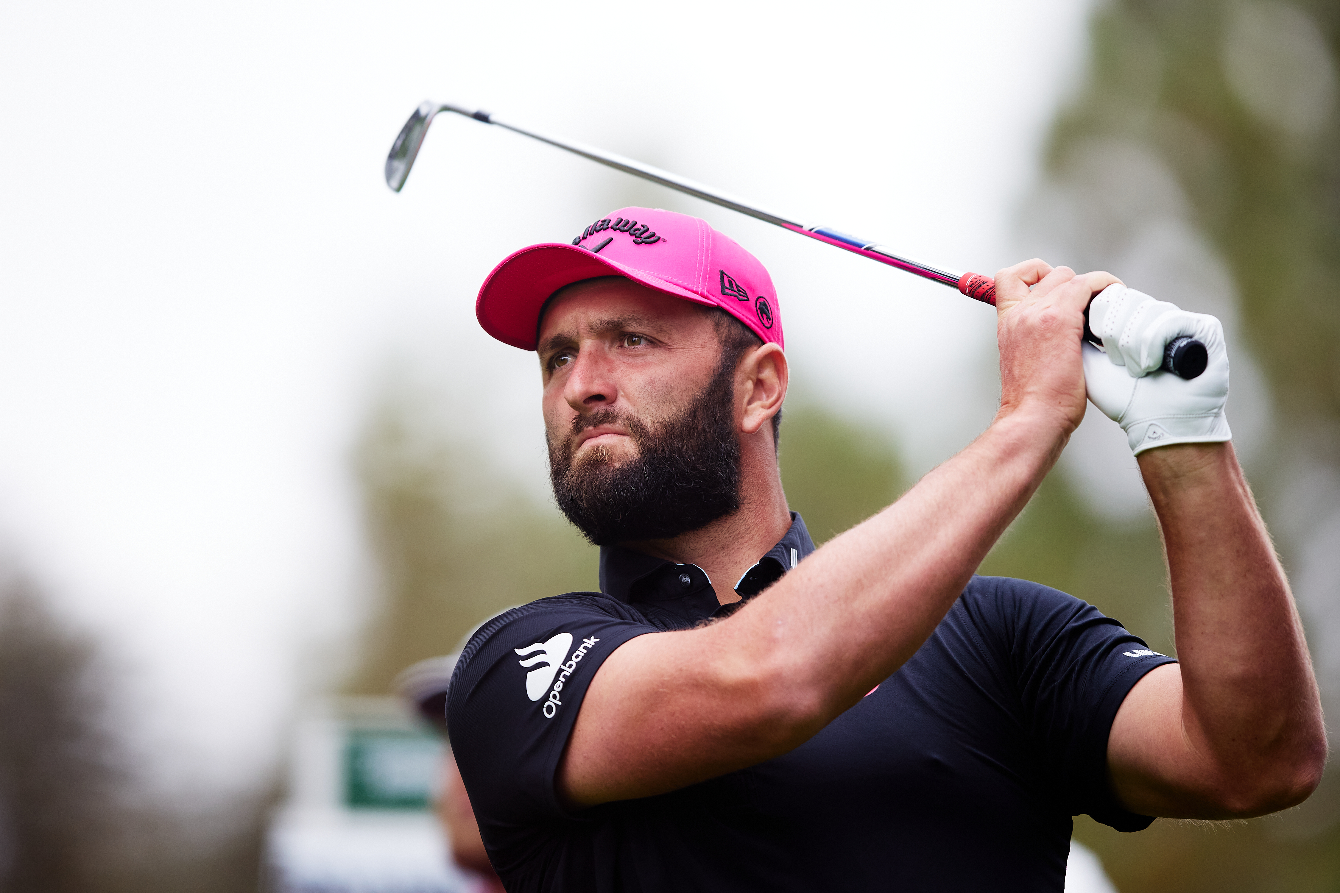 Jon Rahm hits an iron shot and watches its flight