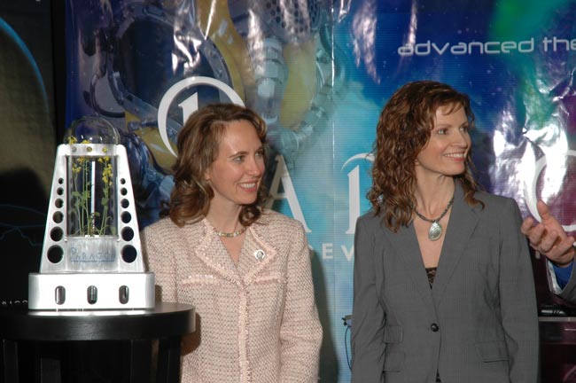 A prototype greenhouse sits next to U.S. Congress Rep. Gabrielle Giffords (left) and Jane Poynter, president and founder of Paragon Space Development Corporation (right). Paragon has teamed up with Odyssey Moon, a contender for the Google Lunar X Prize, t