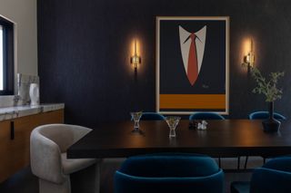 A dramatic intimate blue dining room with wall lights