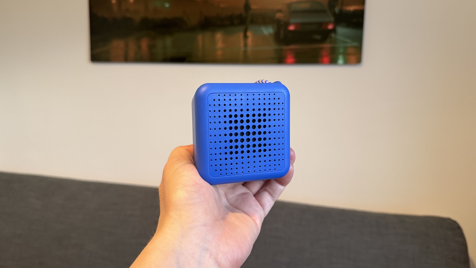 A small, Blue Ikea speaker, photographed in someone's hand