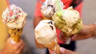 Four ice creams in a variety of flavours held up together, some melting