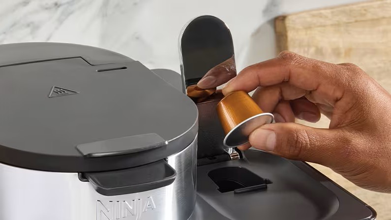 Person inserting capsule in Ninja DualBrew machine