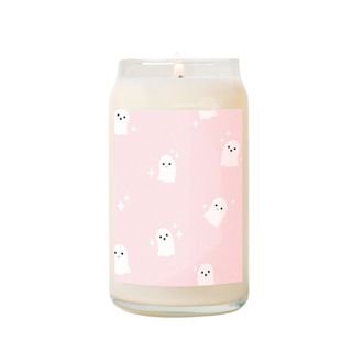 A candle with a pink label with ghost illustrations on it