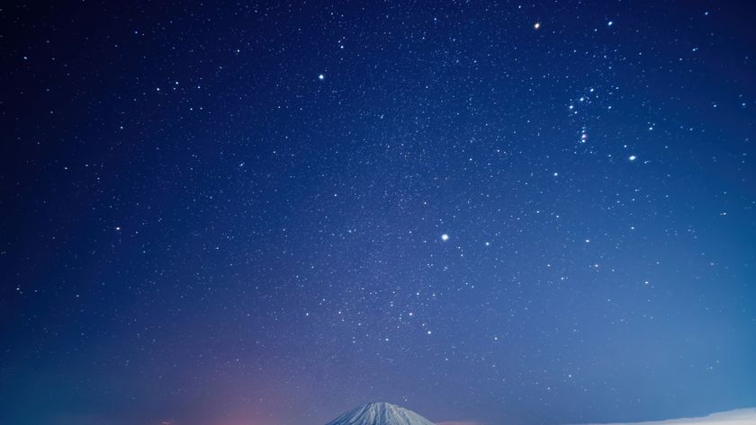 a starry night sky above a snow-capped mountain