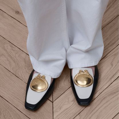 a close up of dior medaillon black and white loafers