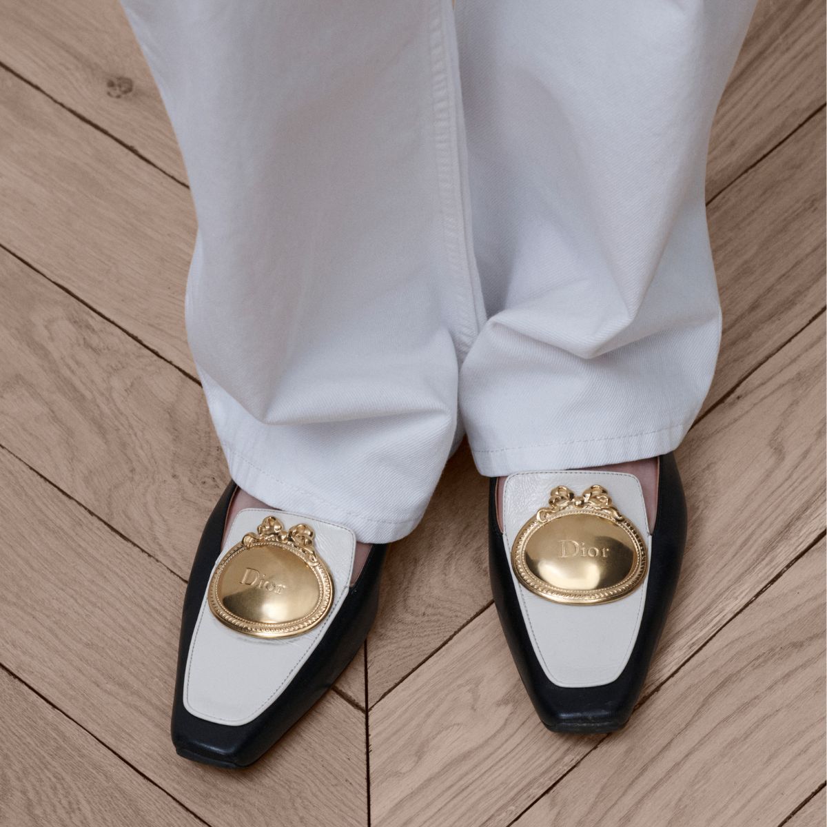 a close up of dior medaillon black and white loafers