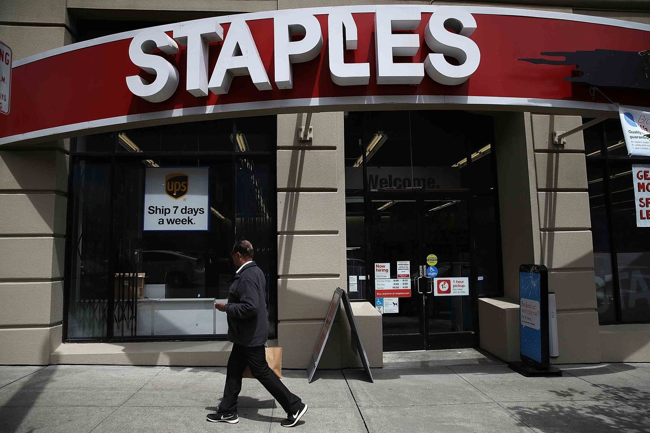 A pedestrian walks by a Staples office supply store in San Francisco, California.