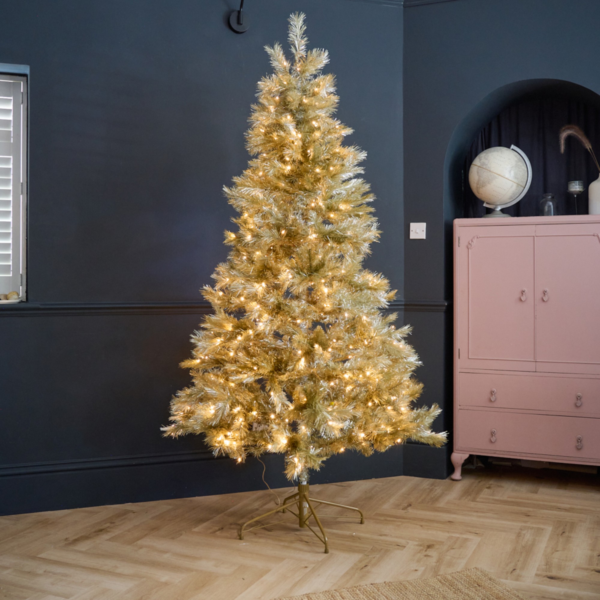 John Lewis' gold Pendleton Pre-lit Christmas Tree in a black-painted living room