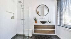 This small bathroom with black tile floor and zero clutter is inspiration for clearing out items interior designers never have in small bathrooms