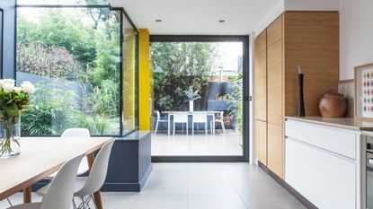 kitchen with dinning table with chair and white wall with kitchen platform