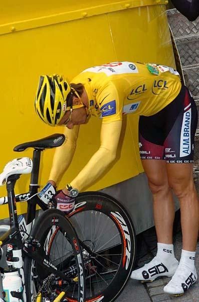Cancellara in yellow makes last adjustments on his bike.