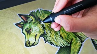 A photo of an artist painting a wolf on the XPPen Artist Pro tablet