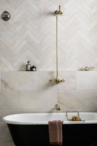 A brass shower above a freestanding bath illustrates how to choose a shower for a traditional scheme.
