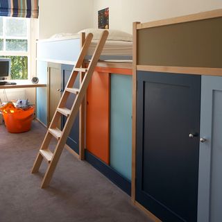 a childs bedroom with a brown ladder leading up to bunk beds , with brown, orange dark blue and light blue storage cupboards underneath