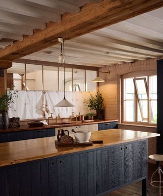 A blue and wood modern rustic kitchen designed by deVOL