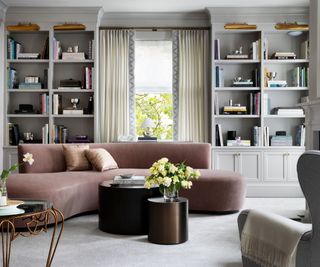 living room with pink curved sofa and alcove shelves