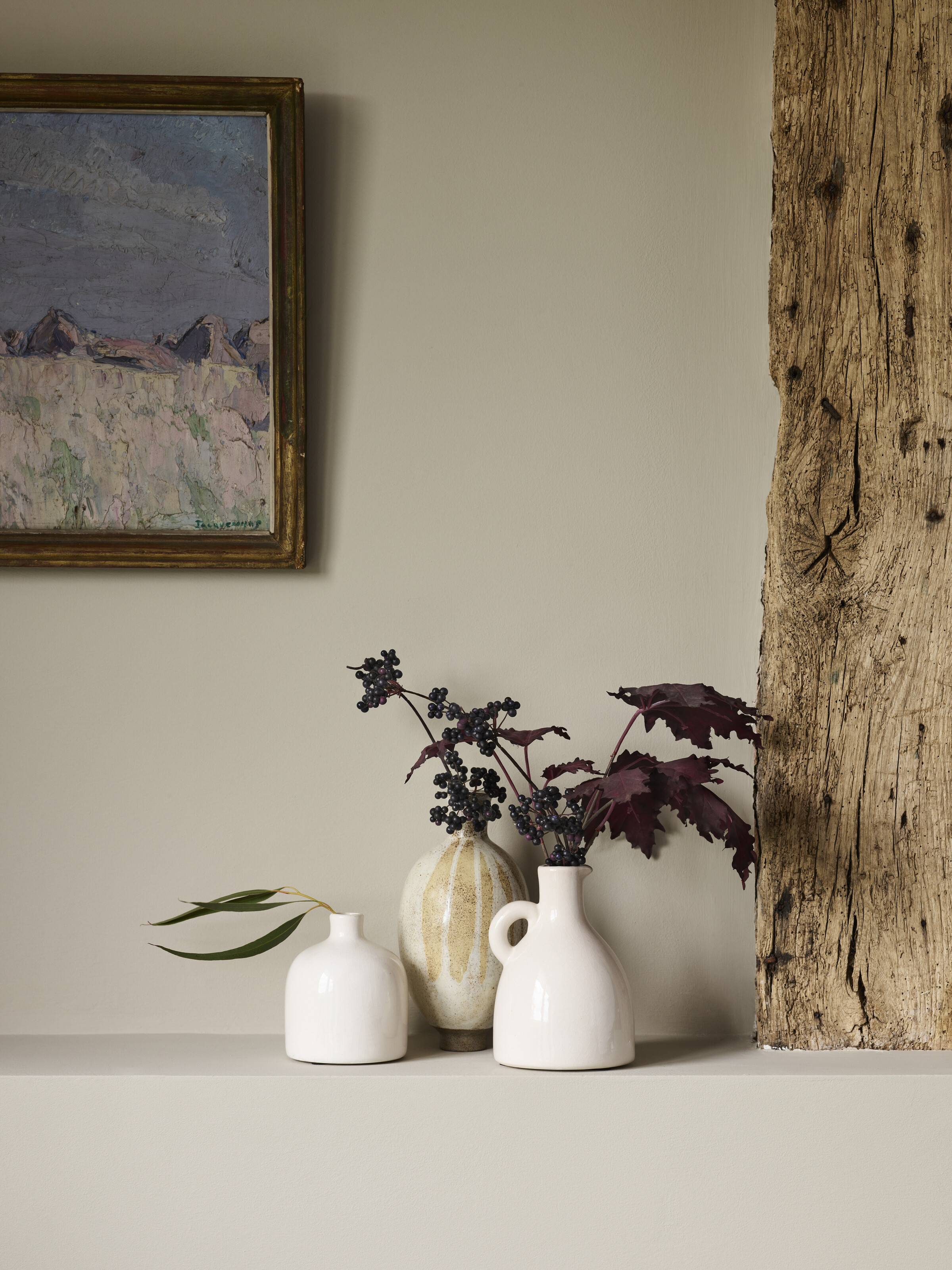 shelf with display of vases and painting hung on wall above