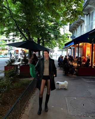 french woman wearing long leather jacket, micro shorts, and tall black boots