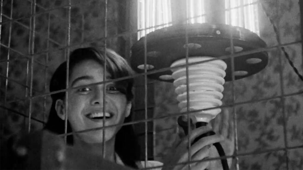 A woman smiling next to bright light in LOLA