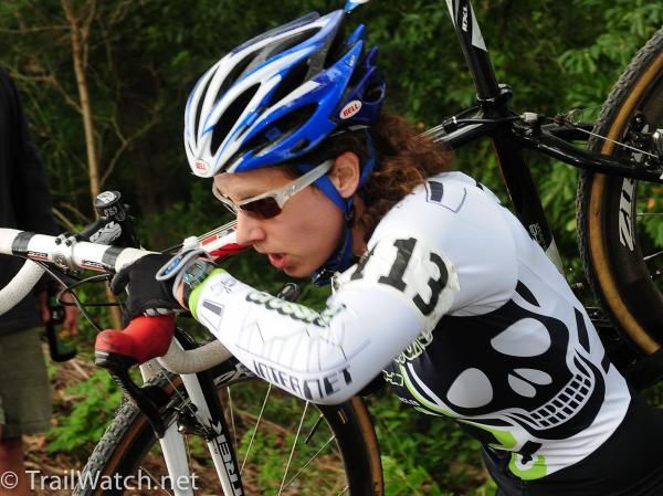 Sara Bresnick-Zocci (crossresults.com) shouldering her bike