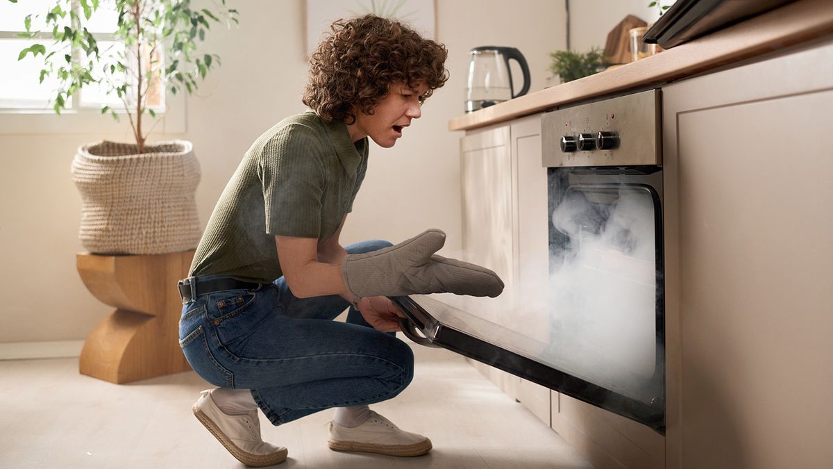 woman opening smoke-filled oven