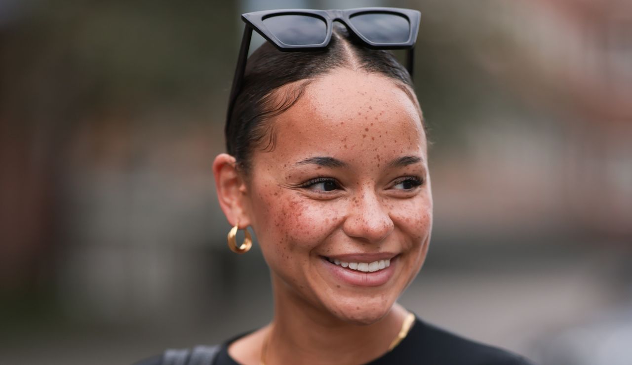 Naomi Amissah seen wearing black sunglasses, gold earrings and necklace, black cropped shirt, black structured leather shopper bag, on August 25, 2023 in Hamburg, Germany.