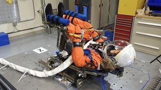 A crash test dummy being prepared for a safety test in a Orion space capsule.