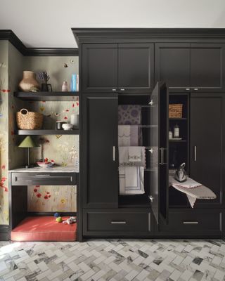 Black cabinet with pull out ironing board, desk and shelves, flower wallpaper