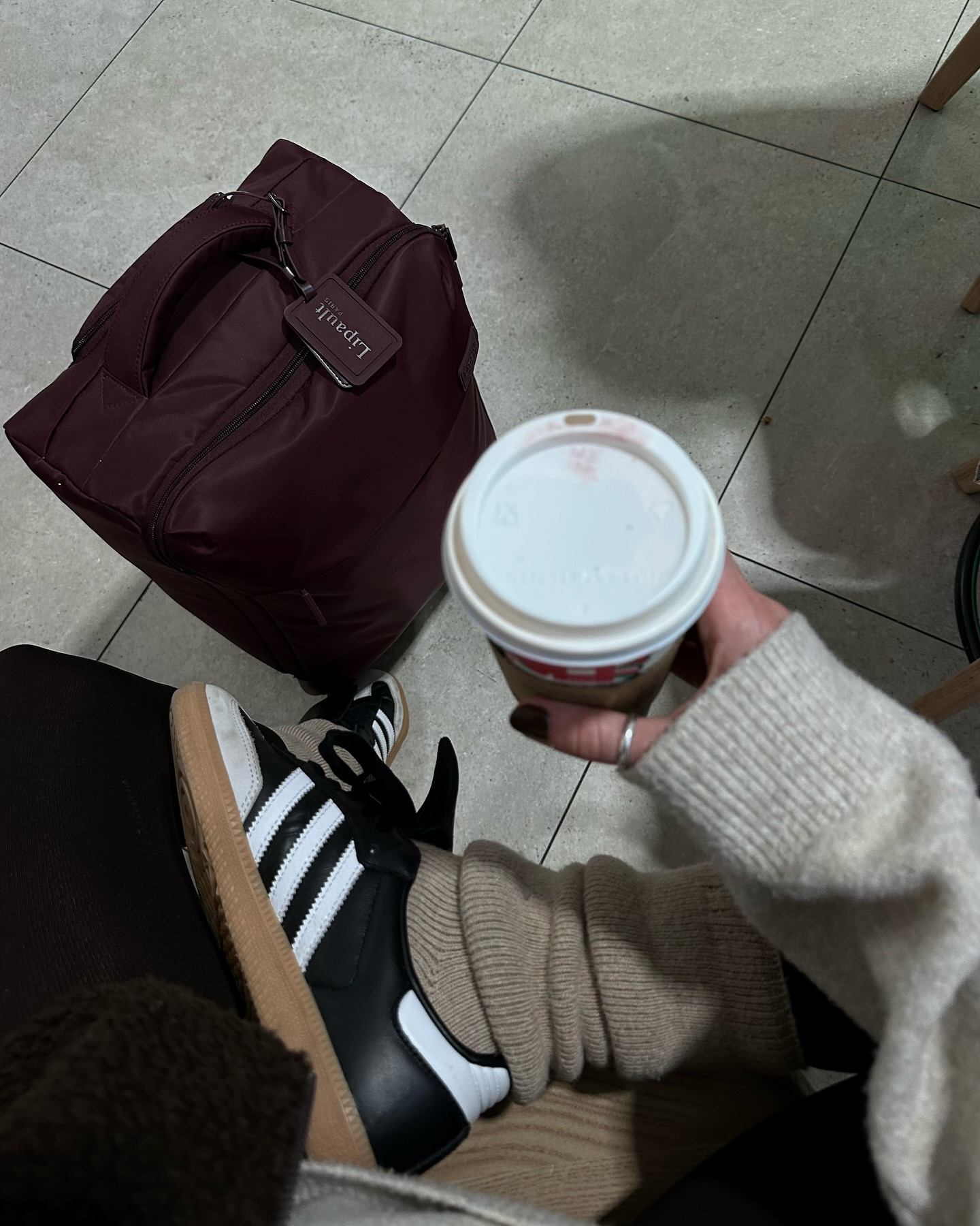 A woman at CDG aiport carries Lipault luggage.