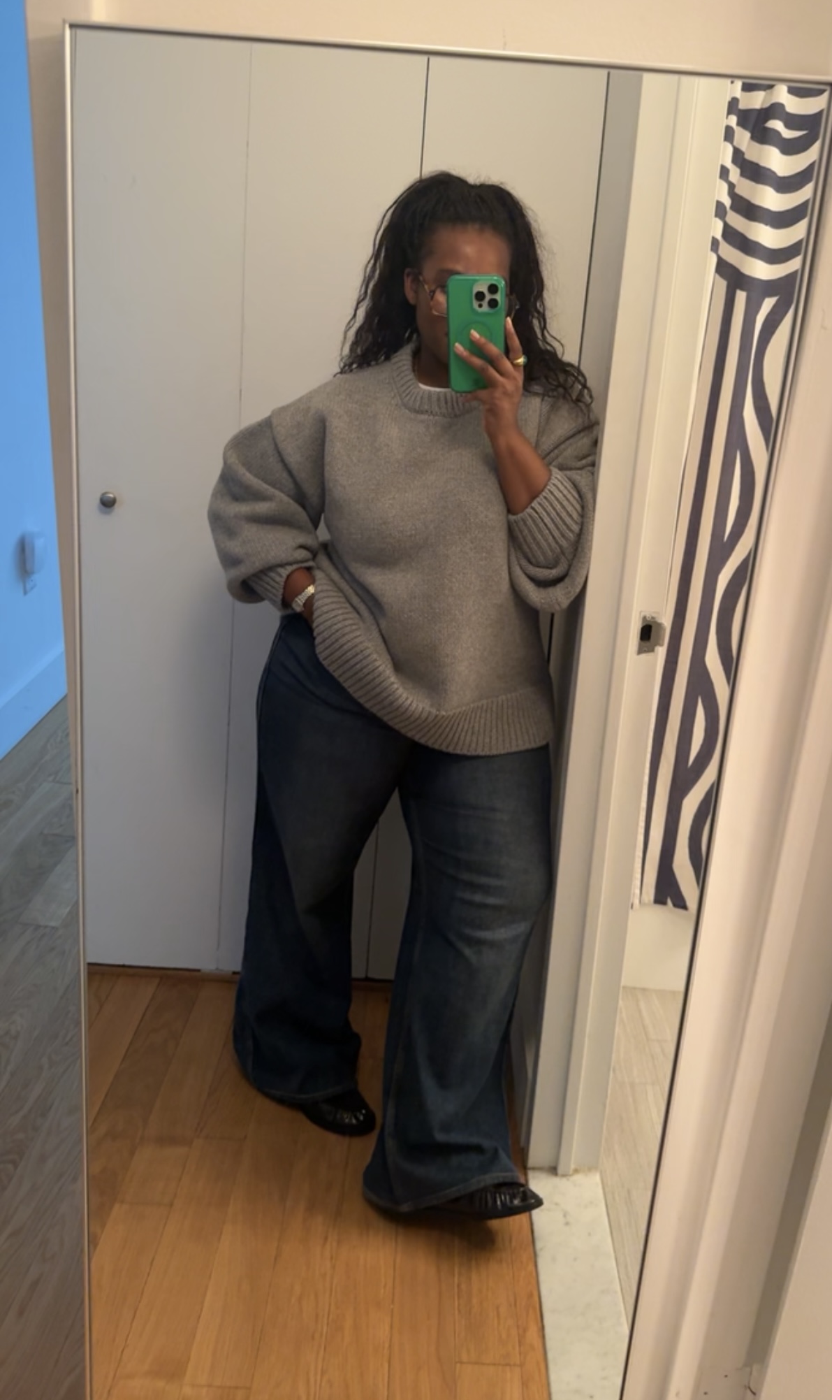 Tariro Makoni wearing a crewneck sweater and jeans