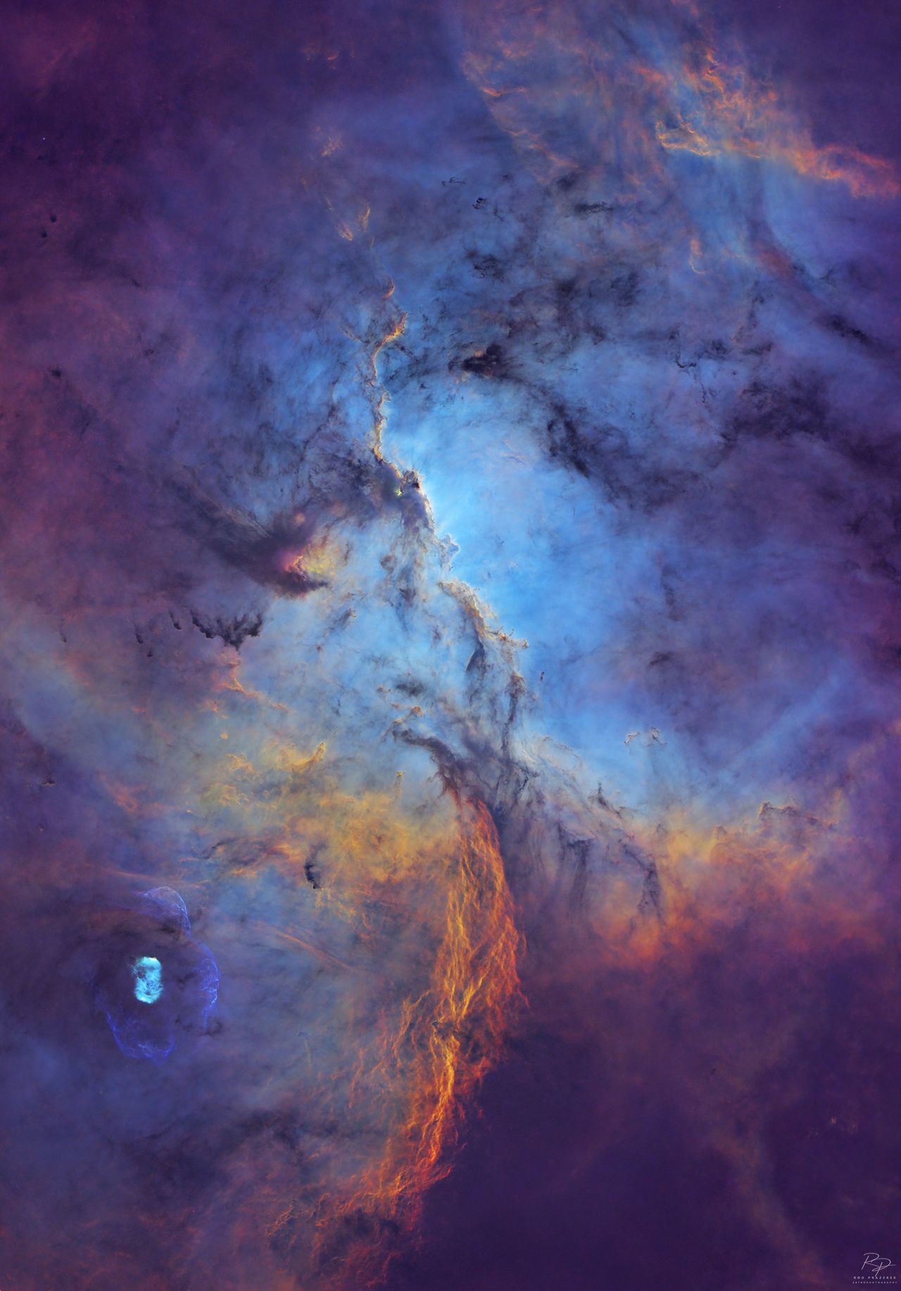 A deep space nebula scene is shown, featuring swirling masses of colorful interstellar gas and dense, dark dust filaments.