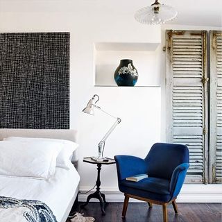 guest bedroom with upholstered bed with anglepoise lamp