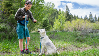 Woman giving her dog a treat on a walk