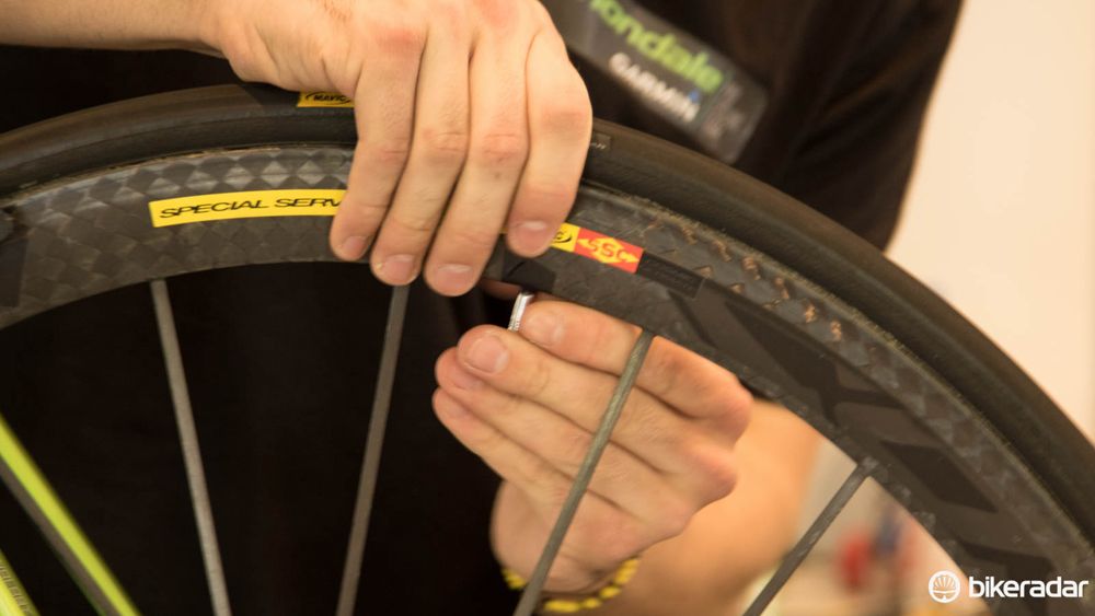 A tiny piece of electrical tape with a hole in it is used to stop a valve rattling within the rim
