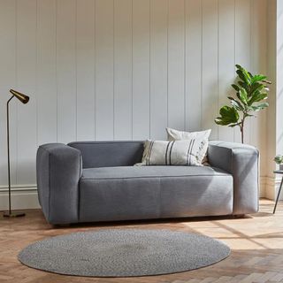 a grey deep-set sofa in a neutral living room