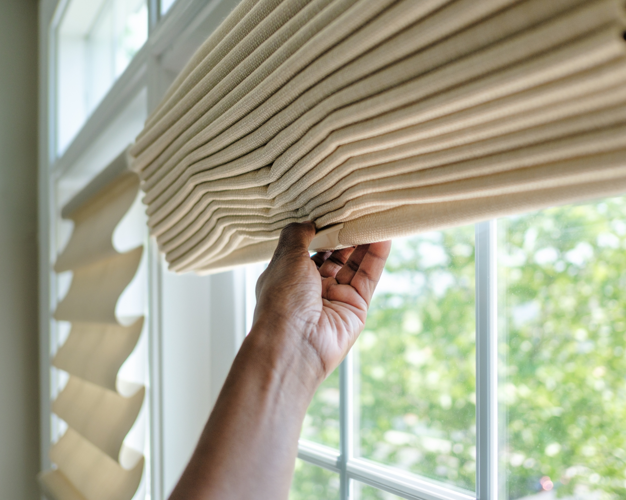 Close-up of unrecognizable black woman lifting window shade