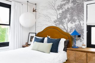 Modern bedroom with mural and yellow velvet headboard