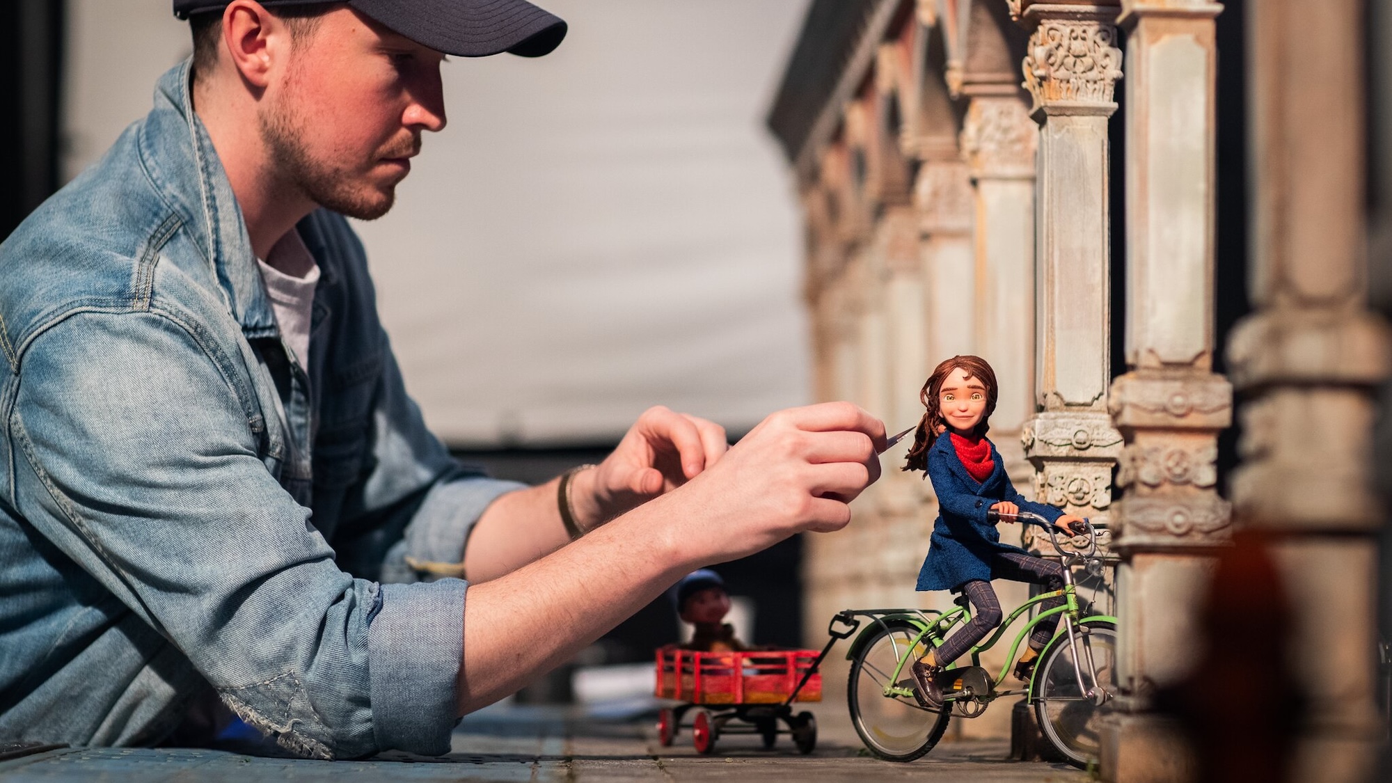 man arranging Prue on a bicycle on the set of Wildwood